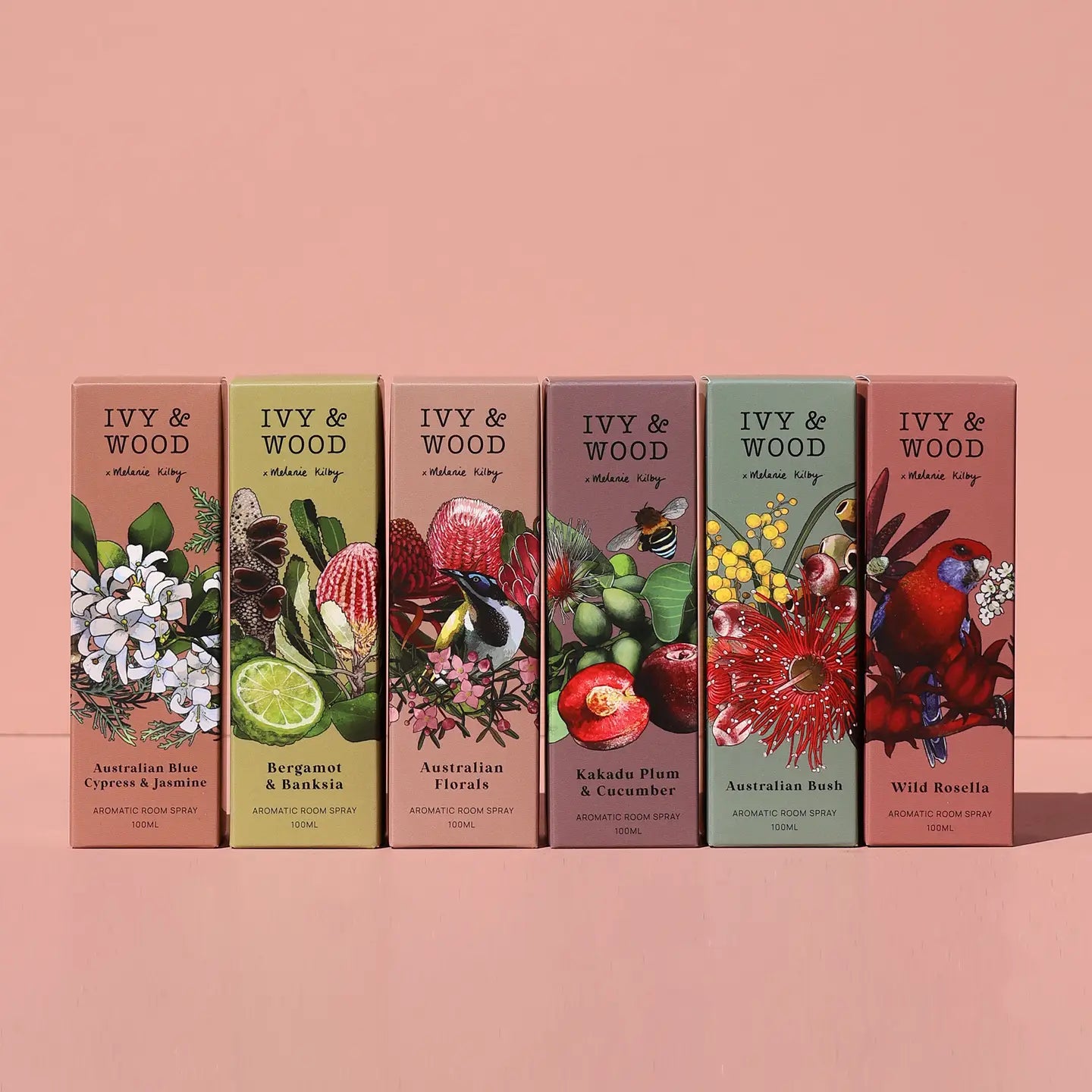 Set of IVY & WOOD room sprays with floral and nature-themed designs on a pink background