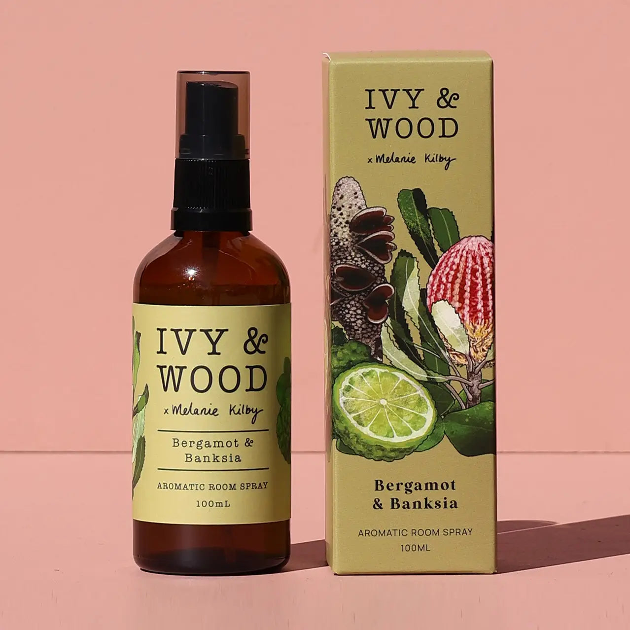 Ivy & Wood Bergamot & Banksia aromatic room spray bottle and packaging on a pink background