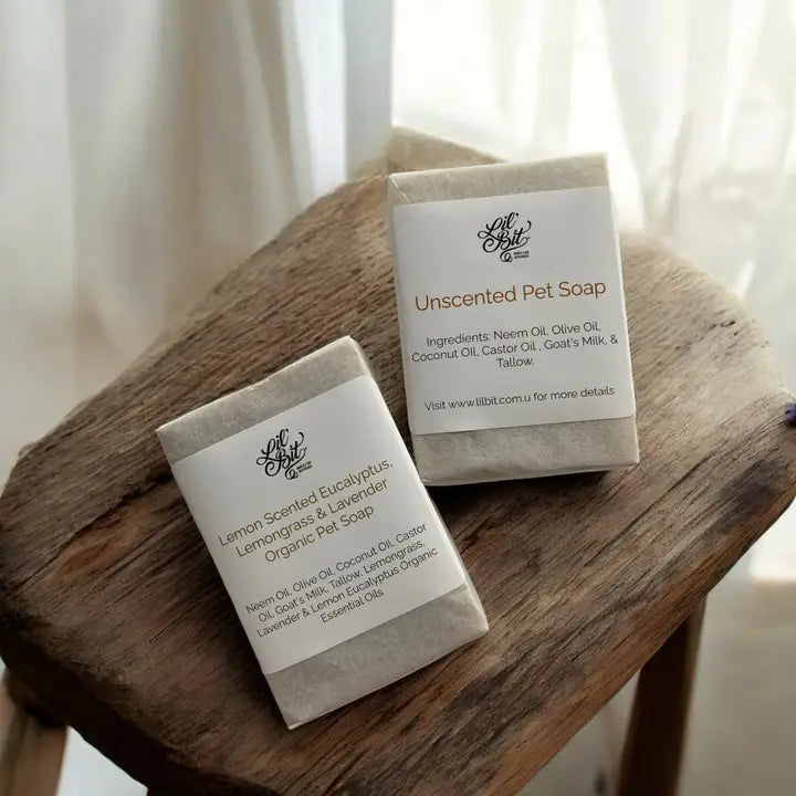 Two bars of packaged organic pet soap displayed on a timber stool