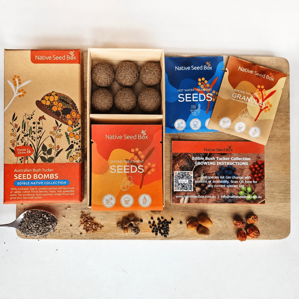 A Native Seed Box collection gift set arranged on a wooden board, including Seed Bombs, Seeds, Granules, and Growing Instructions, with spices and nuts styled around them on a white background.